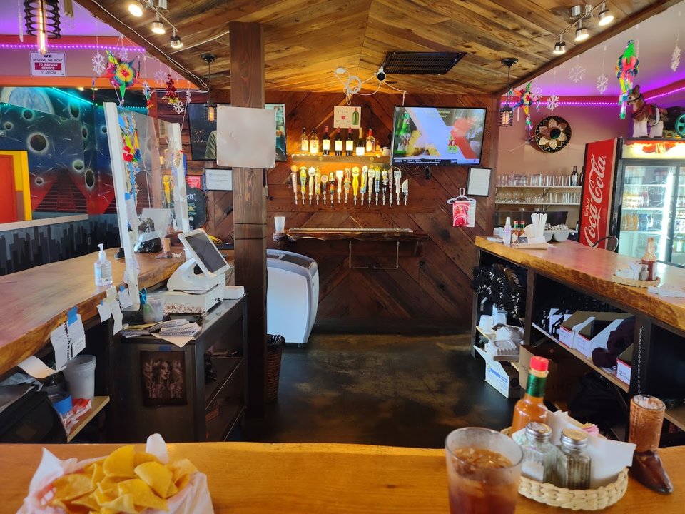 Mexican restaurant interior with seating and warm tones.